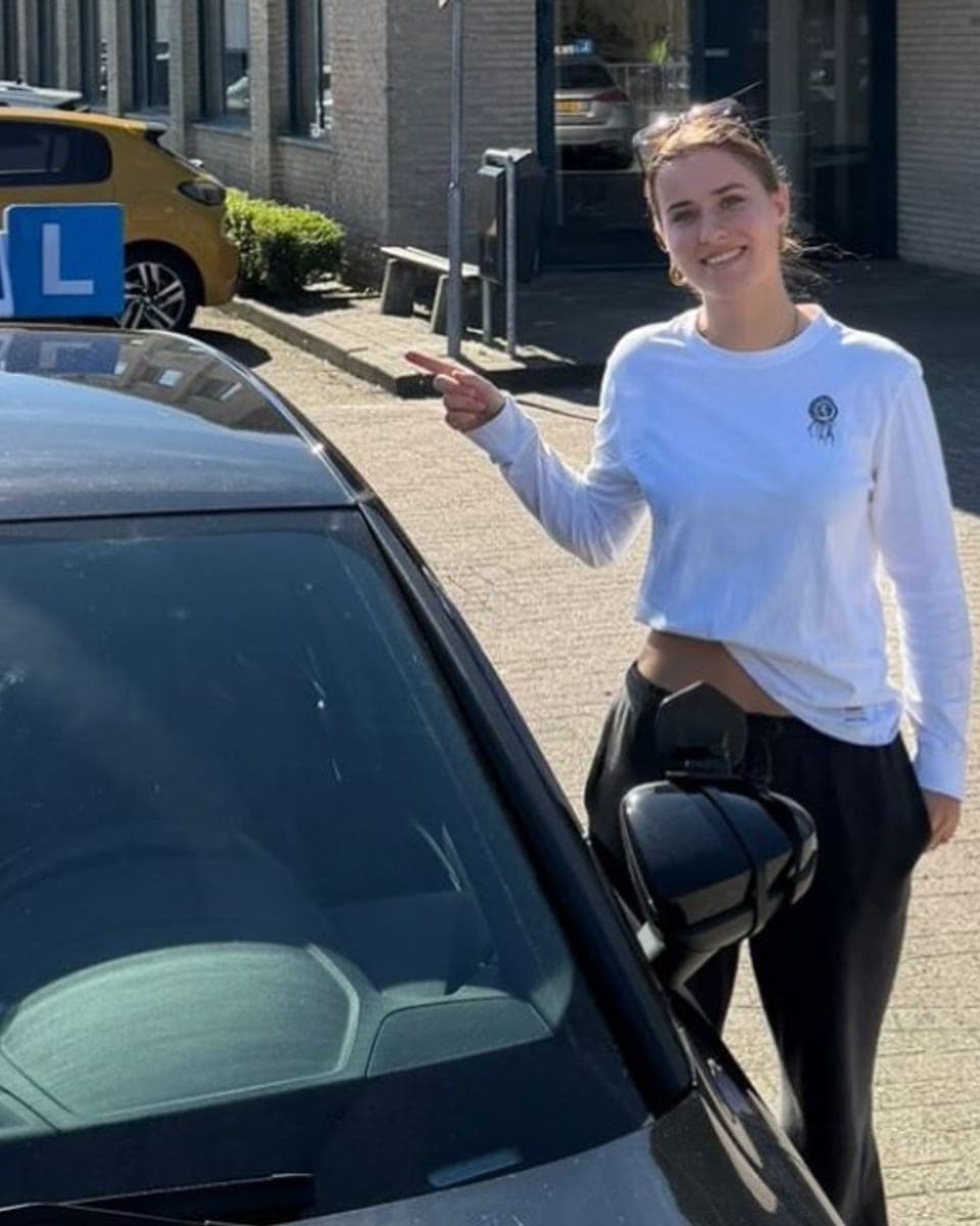 Leerling geslaagd bij Rijcoach Haarlem naast de lesauto