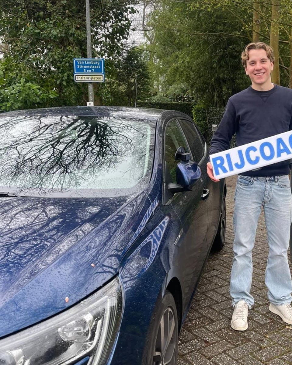 Geslaagde leerling met Rijcoach bord in Heemstede
