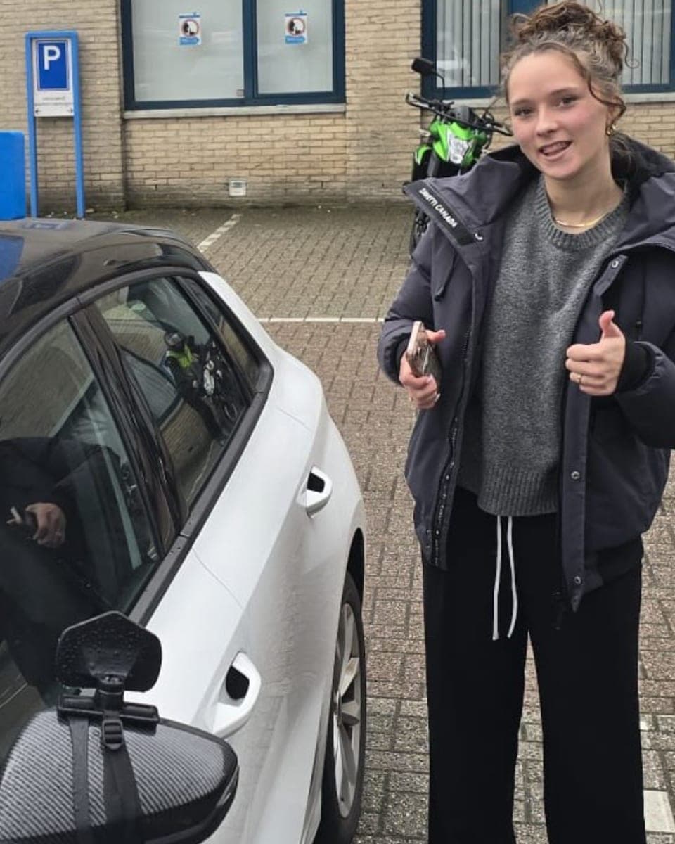 Geslaagde leerling bij Rijcoach Heemstede met duimen omhoog