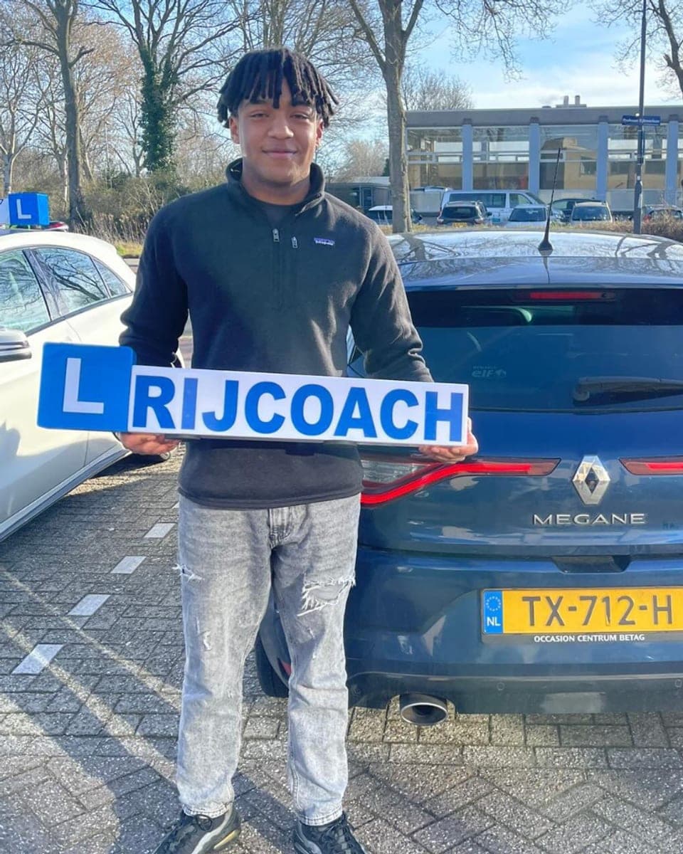 Leerling geslaagd bij Rijcoach Overveen naast de lesauto