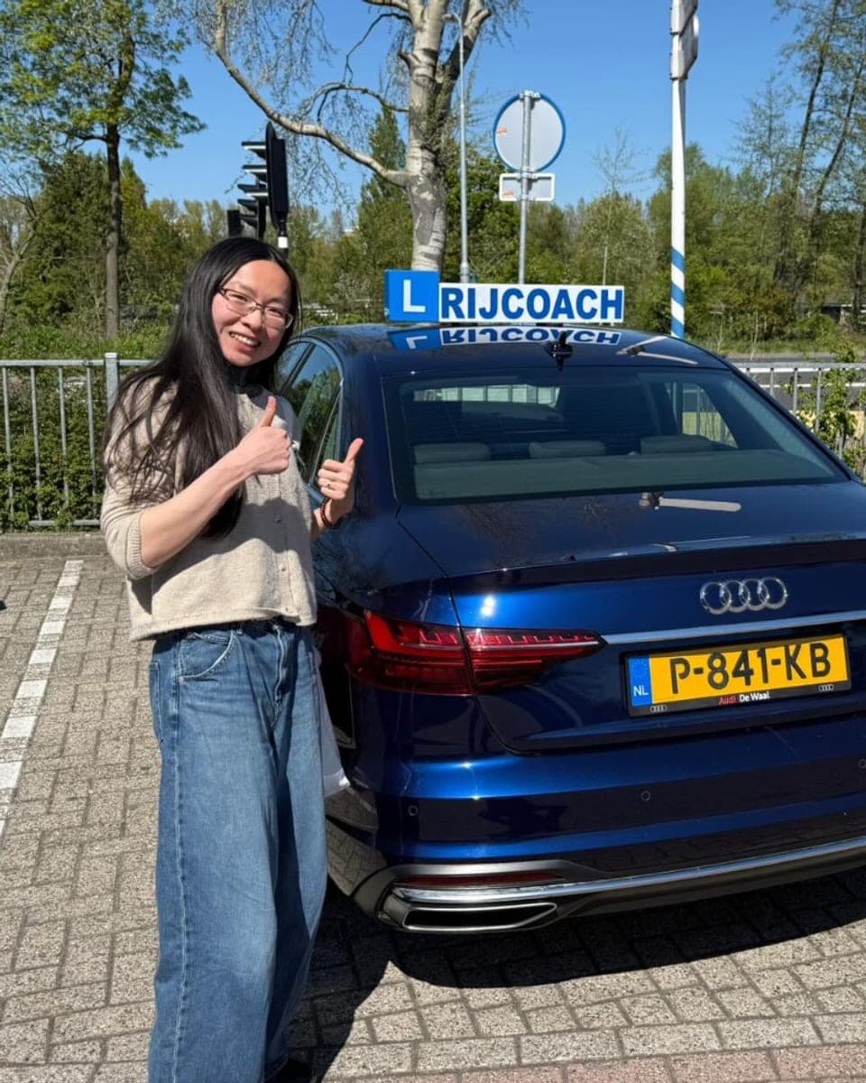 Blije leerling geslaagd bij Rijcoach Zandvoort naast de lesauto