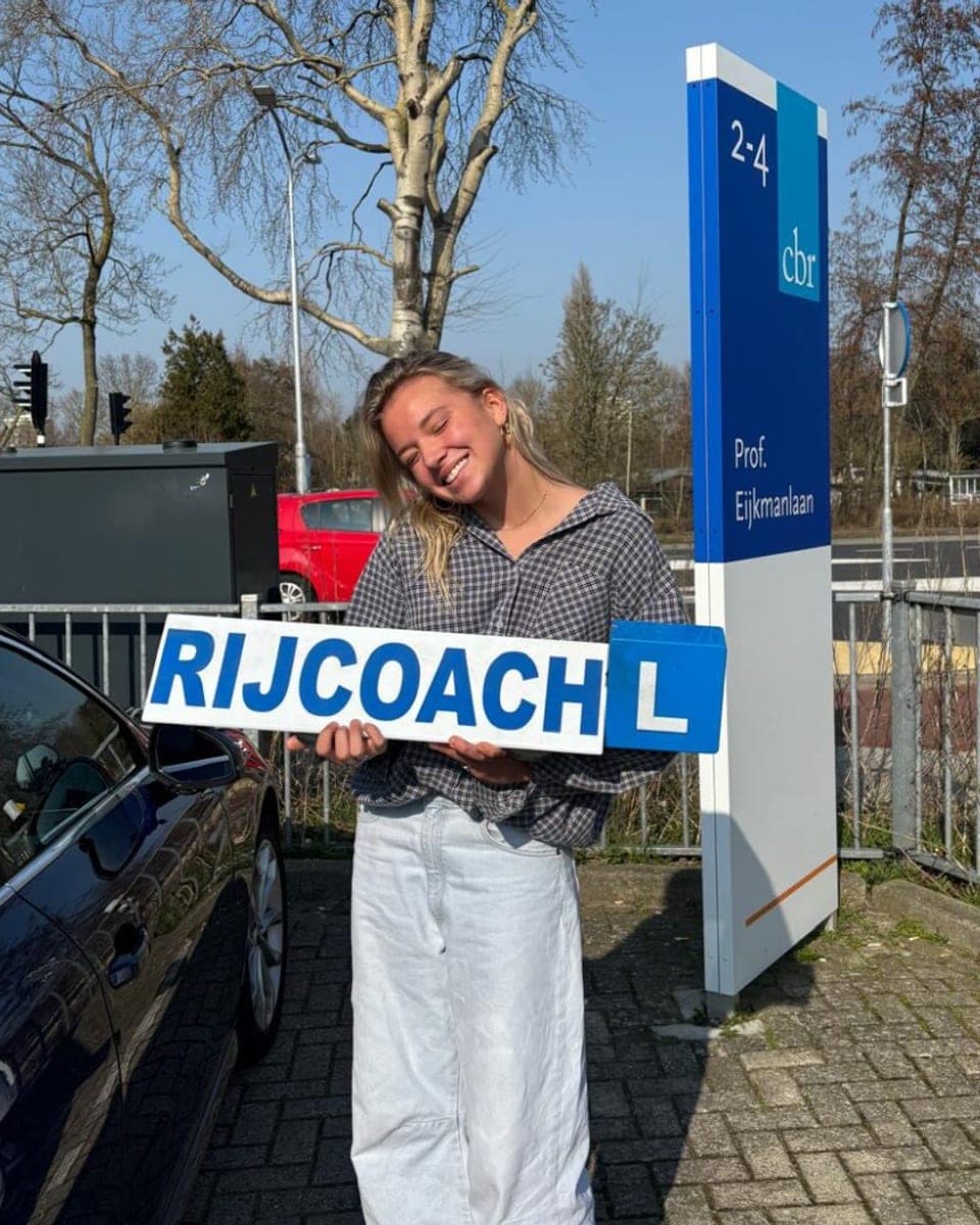 Geslaagde leerling bij Rijcoach Zandvoort naast het CBR-bord