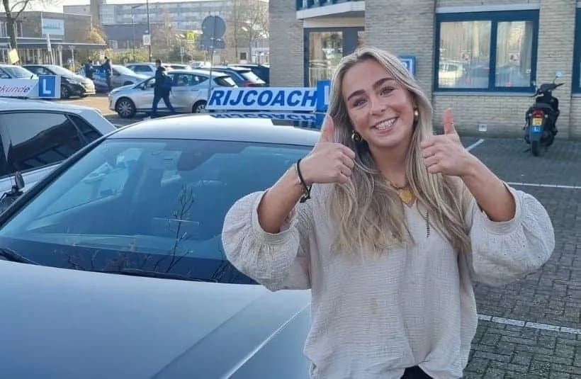 Geslaagd voor je rijbewijs bij Rijcoach in Haarlem, Heemstede en Hoofddorp Geslaagde leerling viert haar rijbewijs naast de Rijcoach-lesauto in Haarlem
