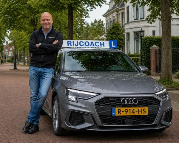 Rob Nijdam from Rijcoach with the gray Audi driving school car in Haarlem